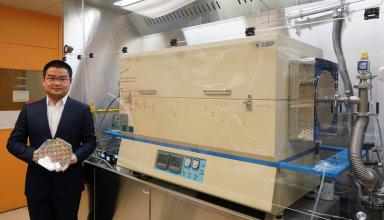 Graduate student Jiadi Zhu holding an 8-inch CMOS wafer with molybdenum disulfide thin film. On the right is the furnace the researchers developed