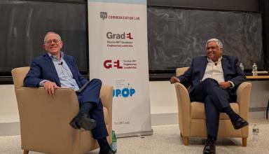 men sitting on chairs in front of audience