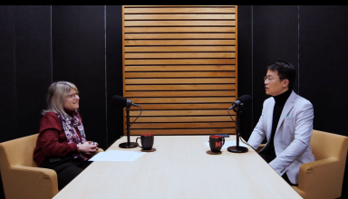 sally Kornbluth and song Han sit across each other at a table