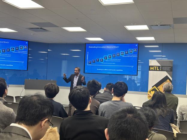 man giving presentation standing in front of slides 