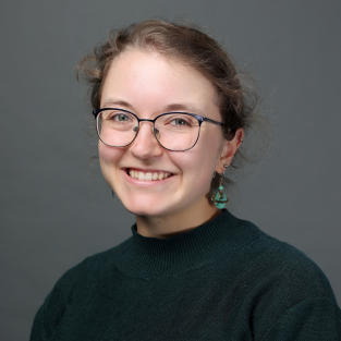 Portrait of Emma Batson, a smiling white woman with light pulled-back hair