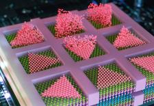  triangles within confined squares directly atop other semiconducting layers (shown in layers of purple, blue, and green)