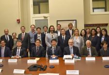 group of men and women sit and stand behind table